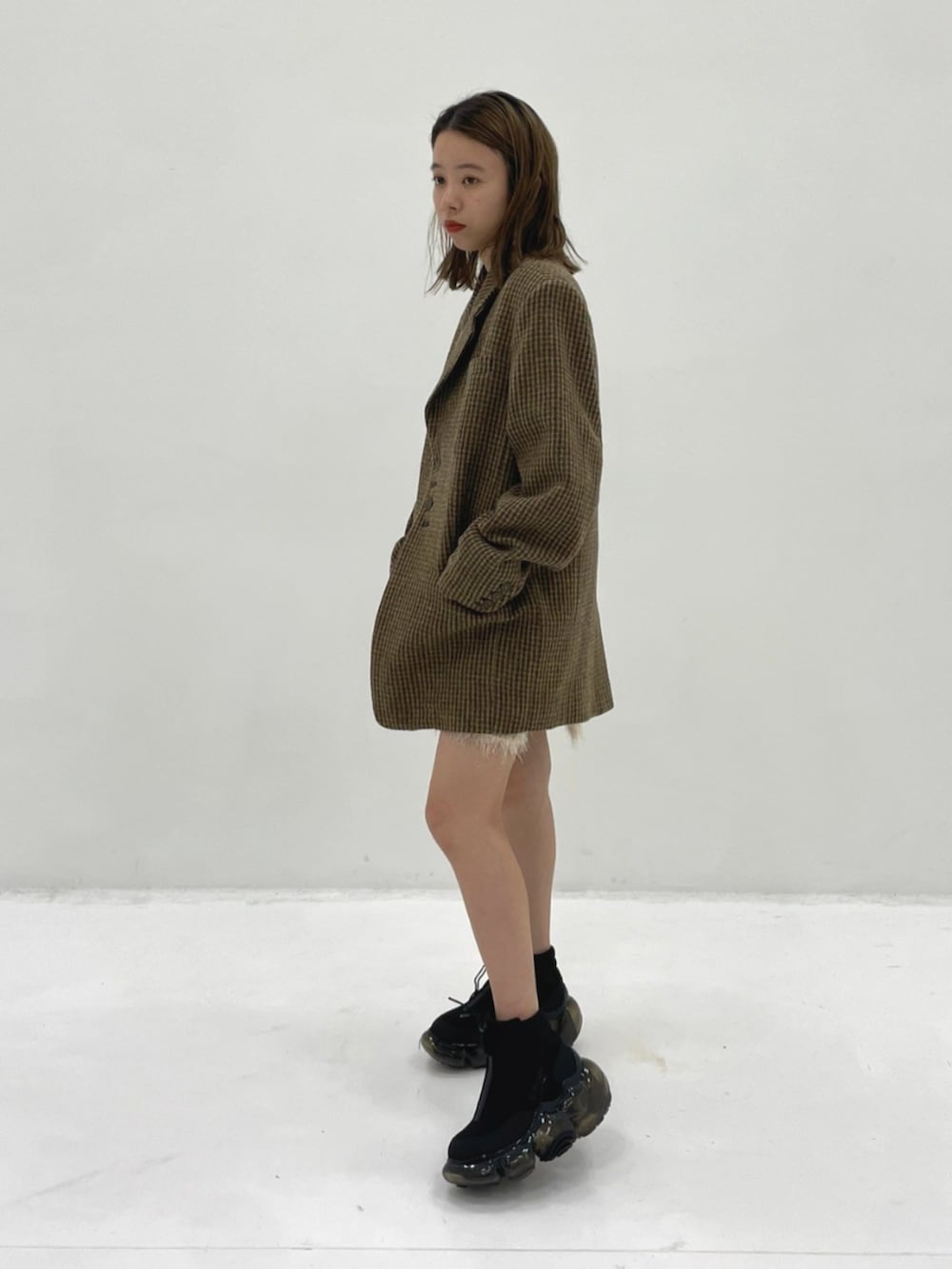 イエロー系のテーラードジャケット、ブラック系のスニーカーを着用したレディースの秋コーディネートの3枚目の写真