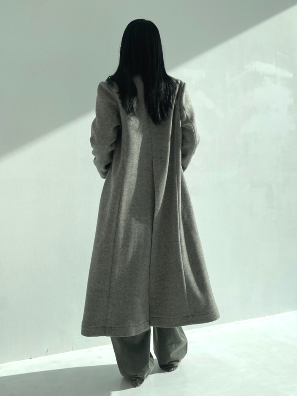 レッド系のパンプス、ブラック系のデニムパンツ、グレー系のチェスターコートを着用したレディースの秋コーディネートの3枚目の写真