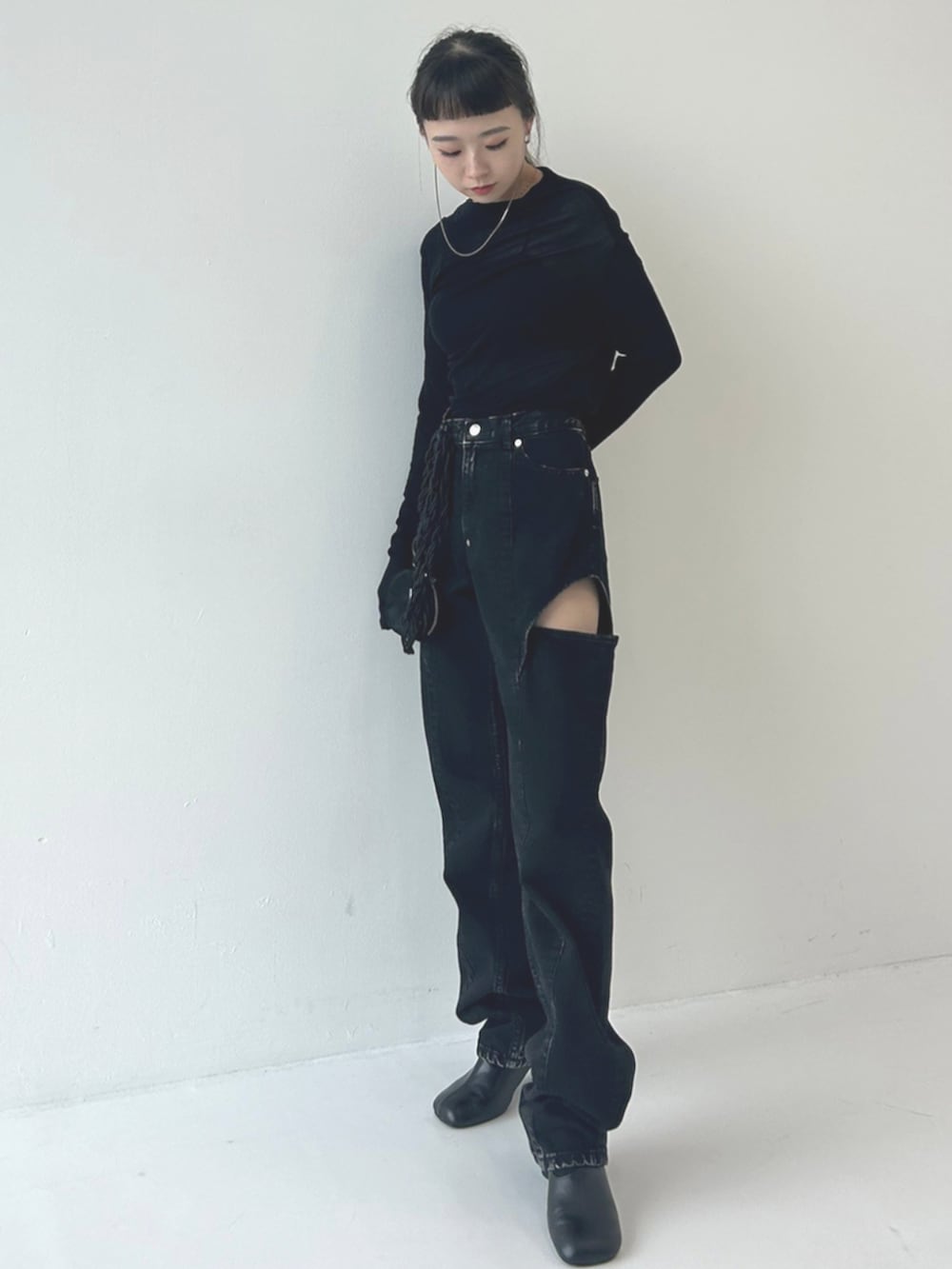 ブラック系のデニムパンツ、ブラック系のスマホグッズを着用したレディースの秋コーディネートの2枚目の写真