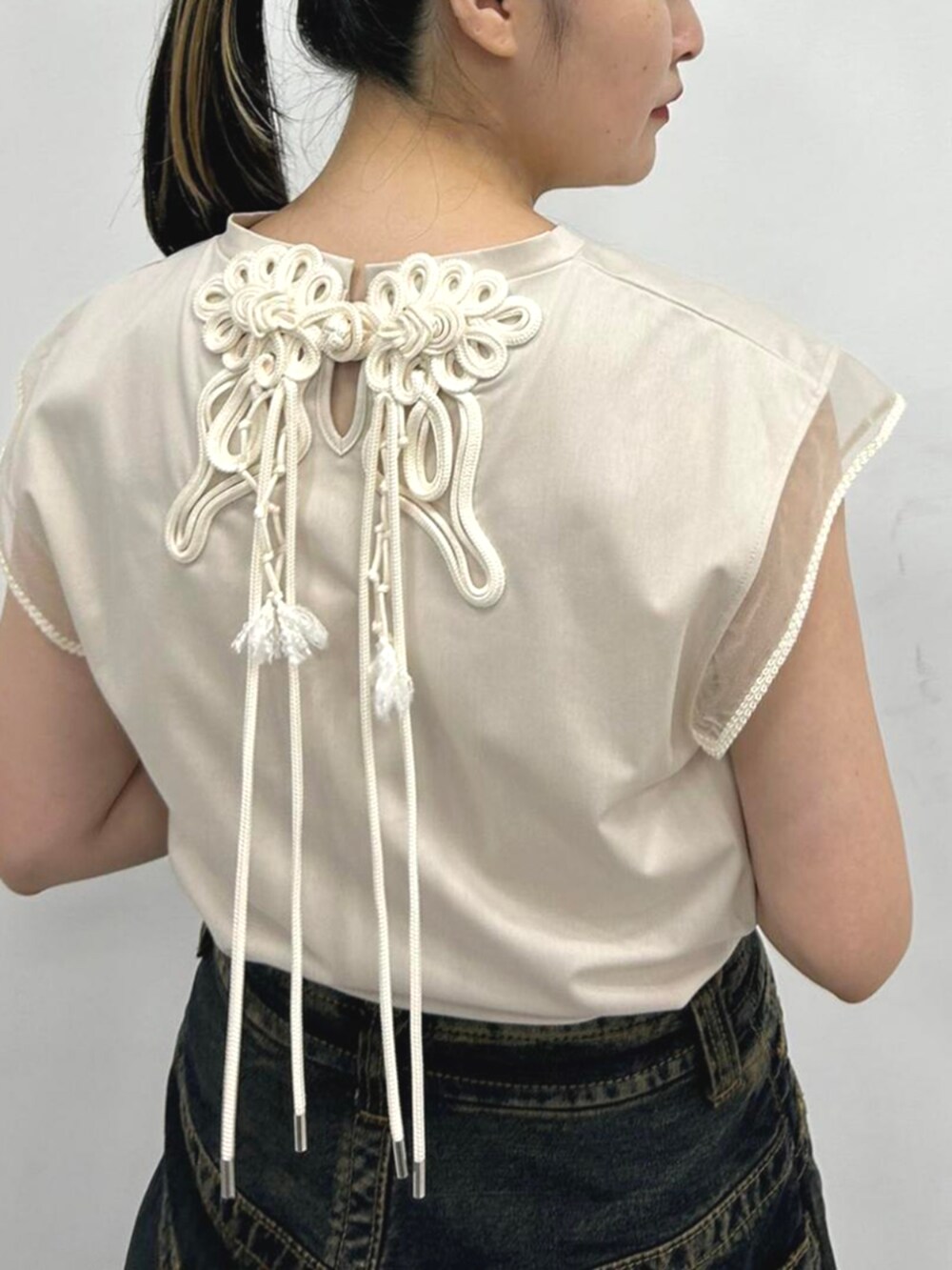 ベージュ系のTシャツ/カットソー、ブラック系のブーツを着用したレディースの夏コーディネートの3枚目の写真