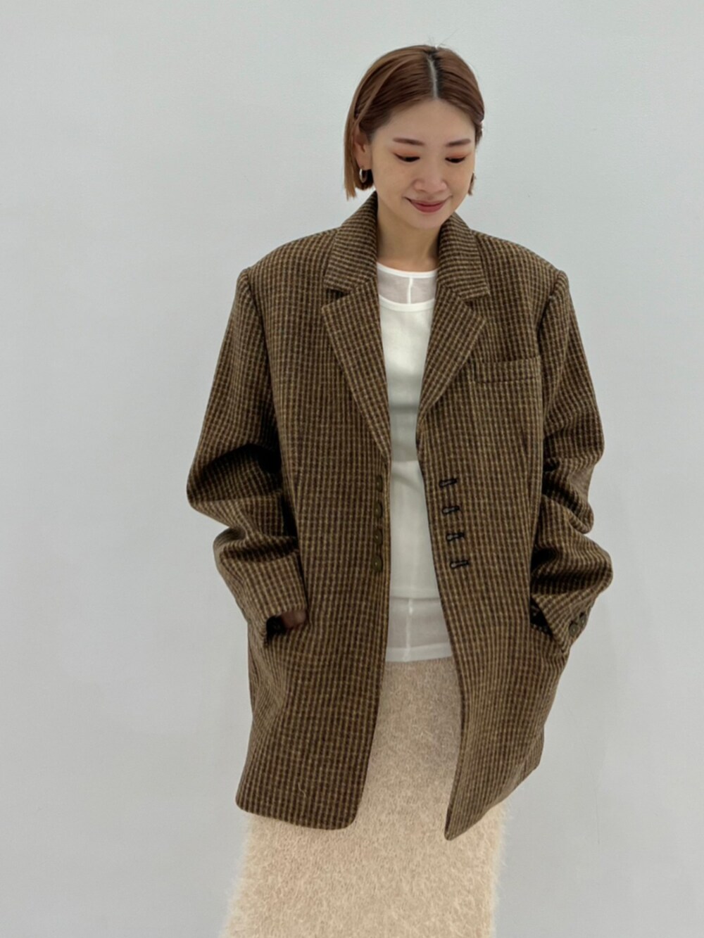 イエロー系のテーラードジャケット、ホワイト系のTシャツ/カットソー、ホワイト系のスカートを着用したレディースの秋コーディネートの4枚目の写真