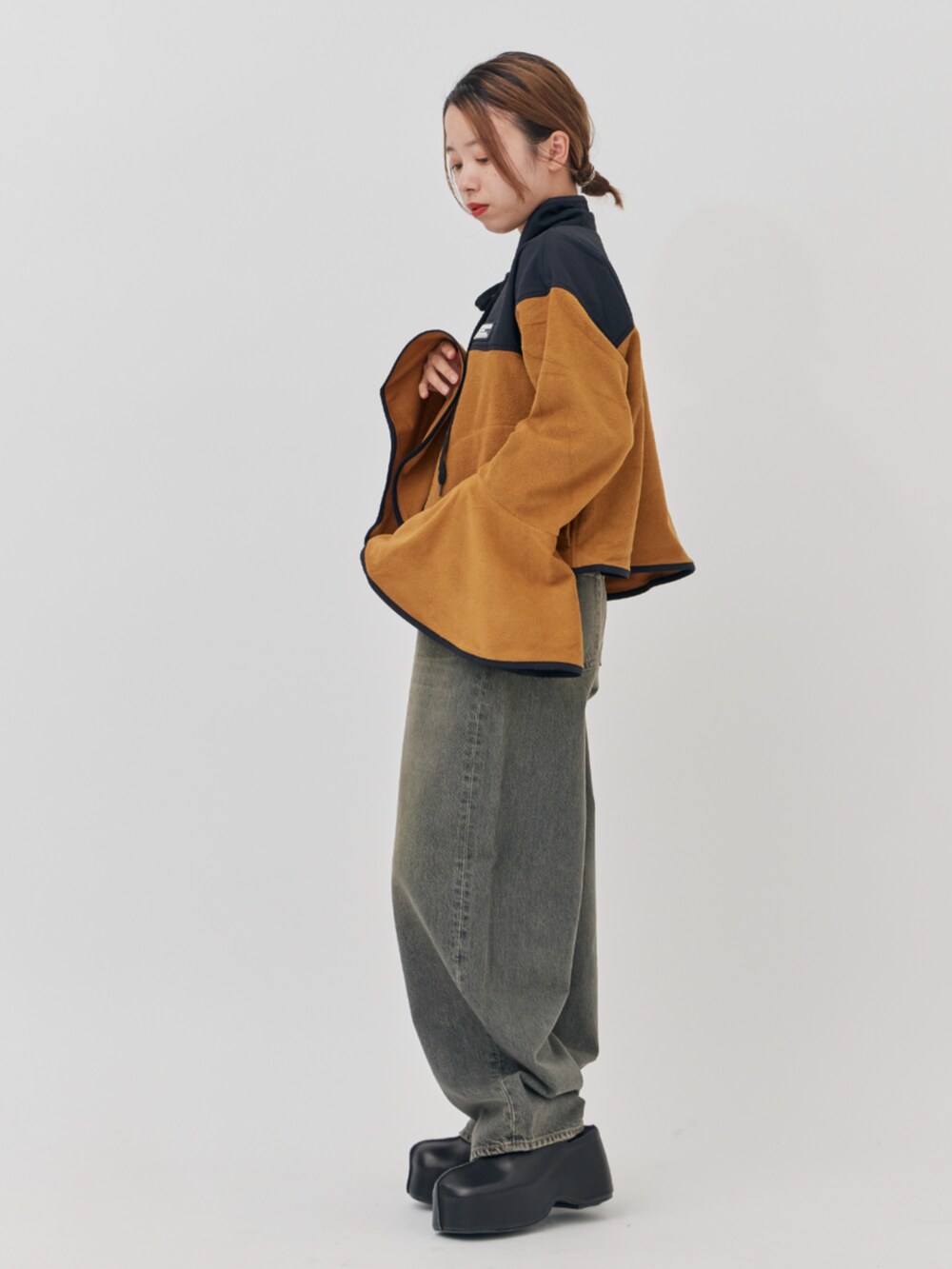 ブラック系のデニムパンツ、イエロー系のその他トップスを着用したレディースの秋コーディネートの2枚目の写真