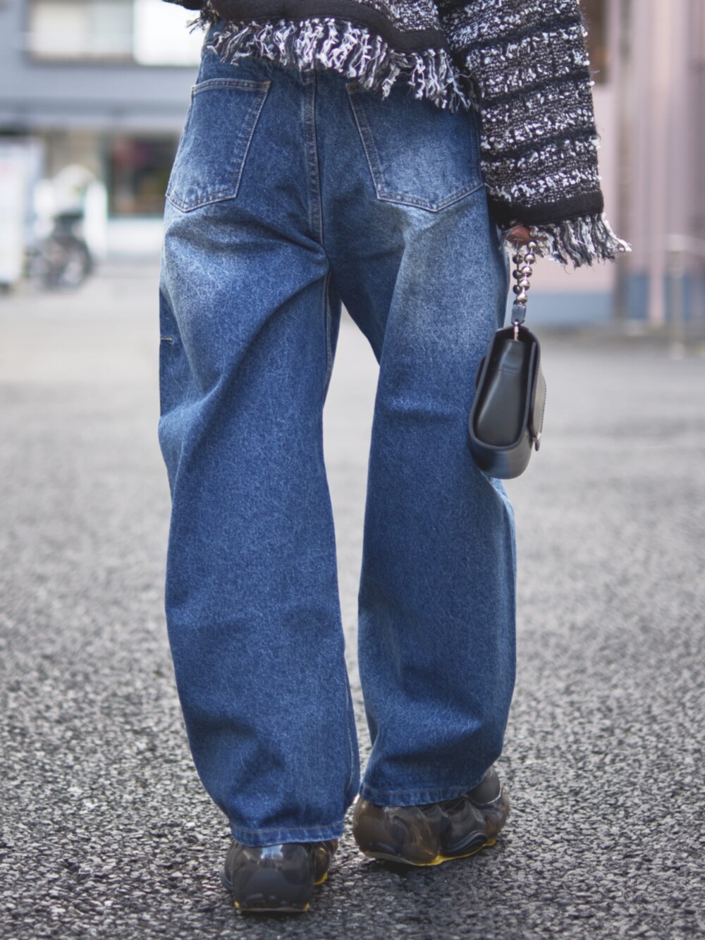 ブラック系のカーディガン/ボレロ、ブルー系のデニムパンツを着用したレディースの冬コーディネートの7枚目の写真