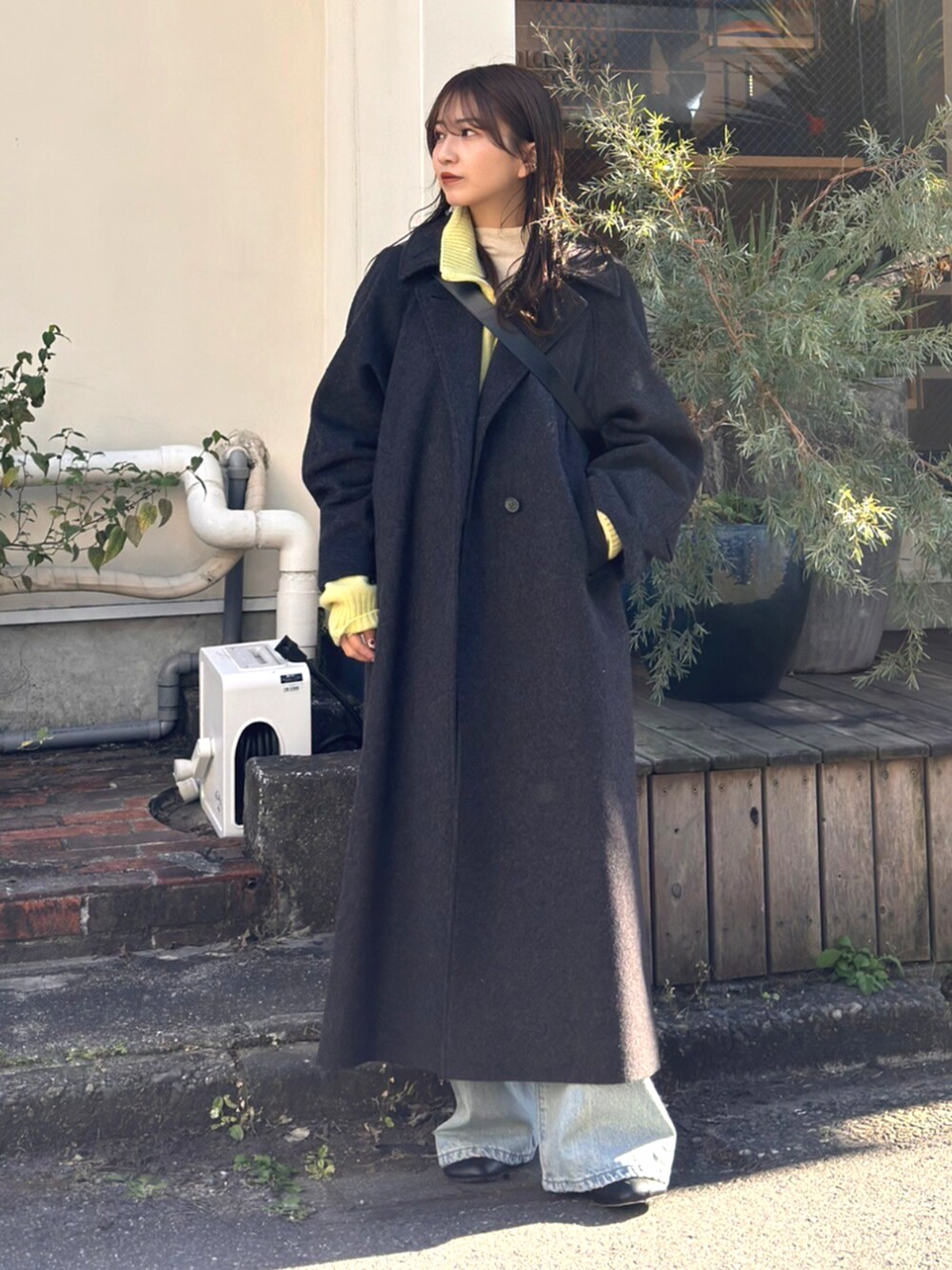 ブルー系のデニムパンツ、グリーン系のニット/セーター、グレー系のその他アウターを着用したレディースの秋コーディネートの2枚目の写真