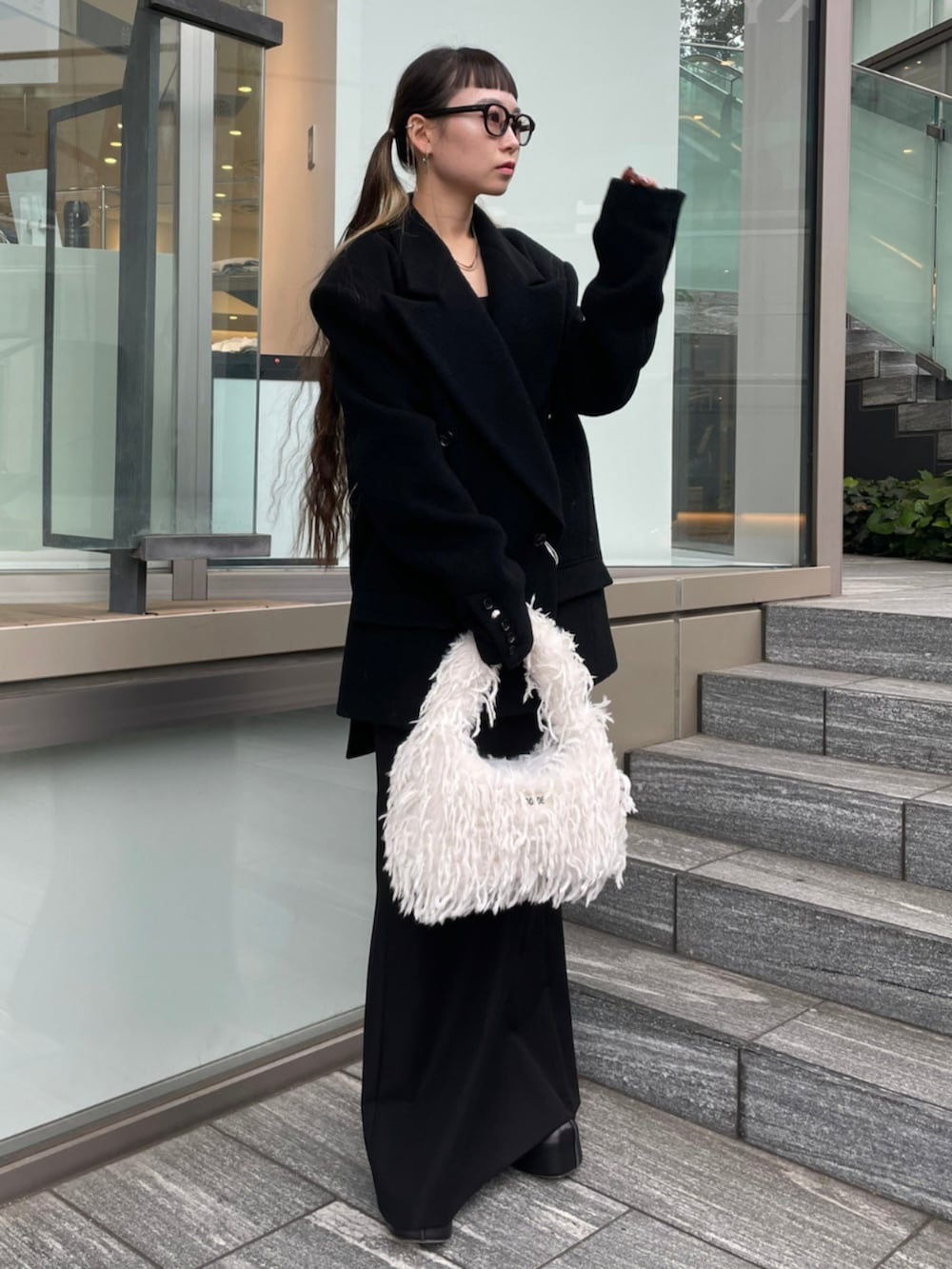 ブラック系のテーラードジャケット、ホワイト系のショルダーバッグを着用したレディースの秋コーディネートの2枚目の写真