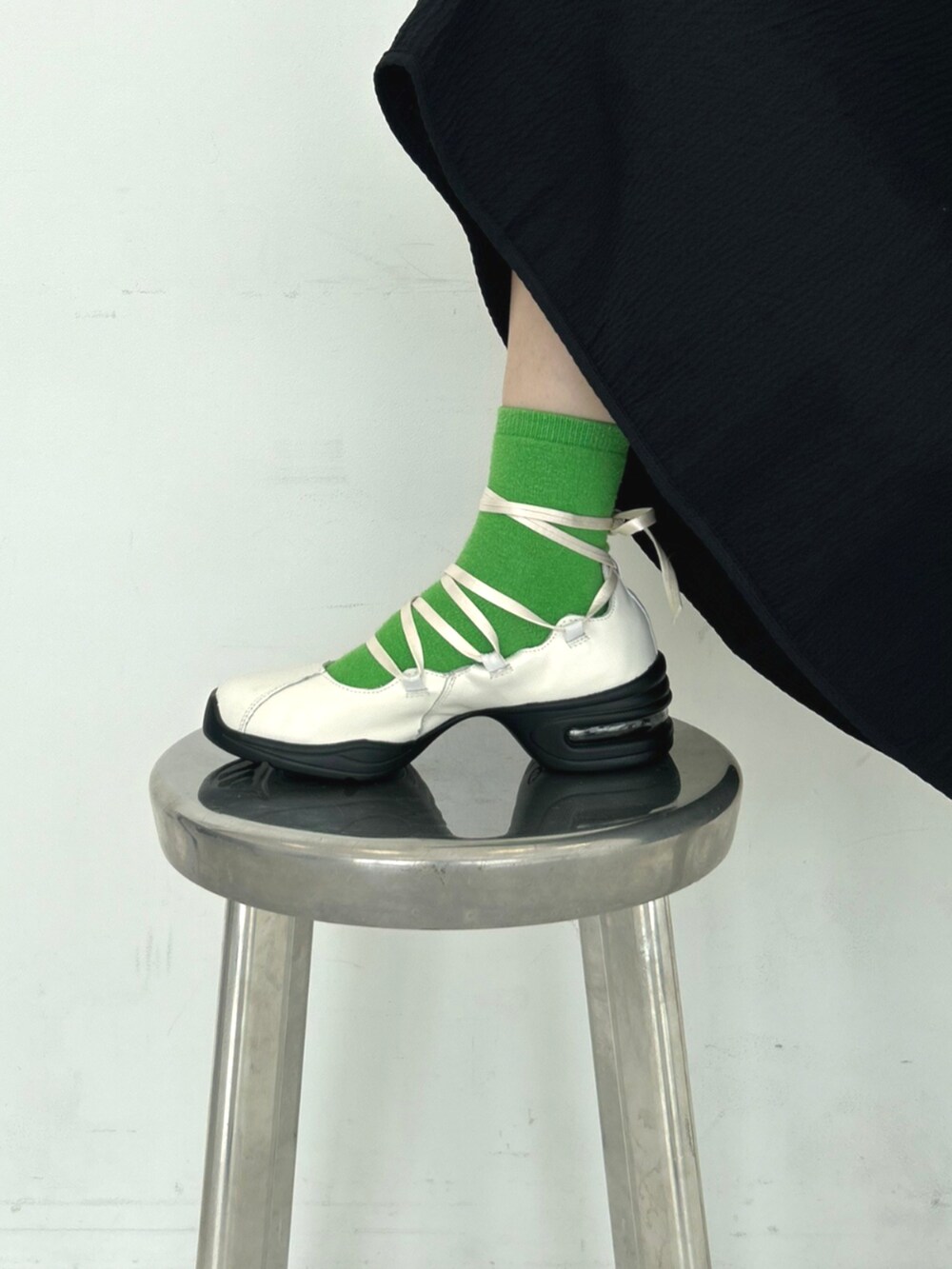 ブラック系のワンピース、ホワイト系のバレエシューズを着用したレディースの秋コーディネートの4枚目の写真