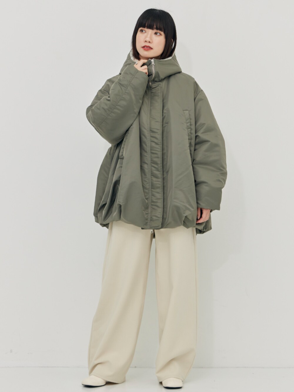 グリーン系のブルゾン、ホワイト系のその他パンツを着用したレディースの秋コーディネートの4枚目の写真