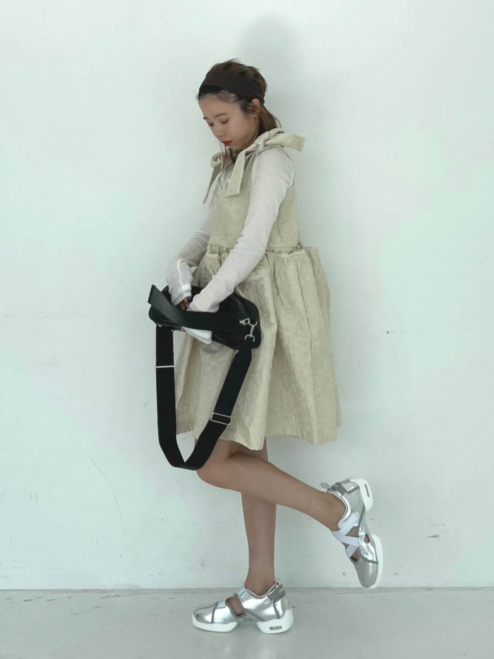 ブラック系のショルダーバッグ、ホワイト系のワンピースを着用したレディースの秋コーディネートの2枚目の写真