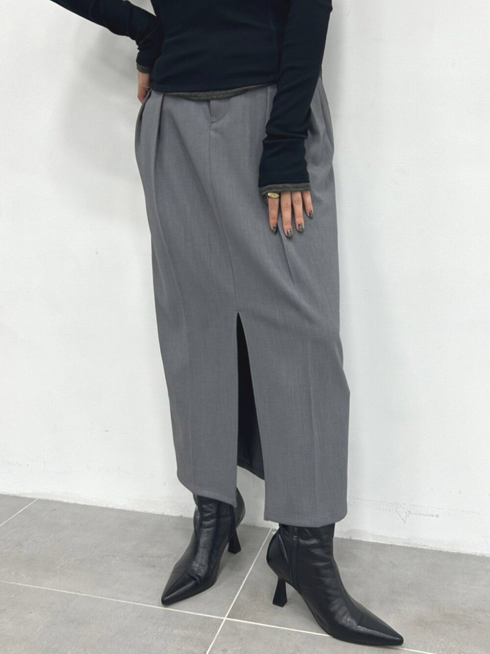 グレー系のタンクトップ、ブラック系のTシャツ/カットソー、グレー系のスカートを着用したレディースの秋コーディネートの4枚目の写真