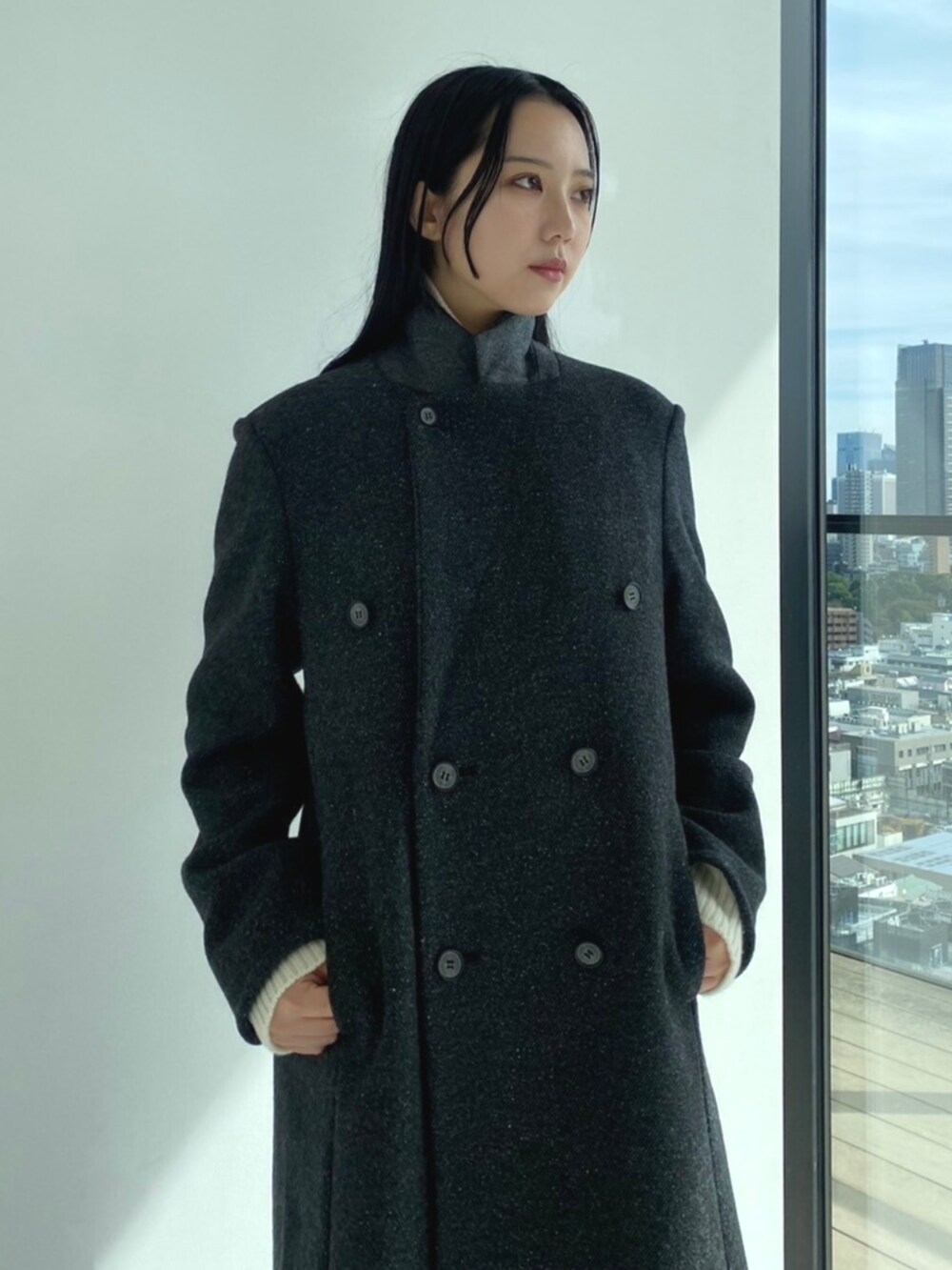 グレー系のチェスターコート、ホワイト系のニット/セーター、グレー系のスラックスを着用したレディースの秋コーディネートの6枚目の写真