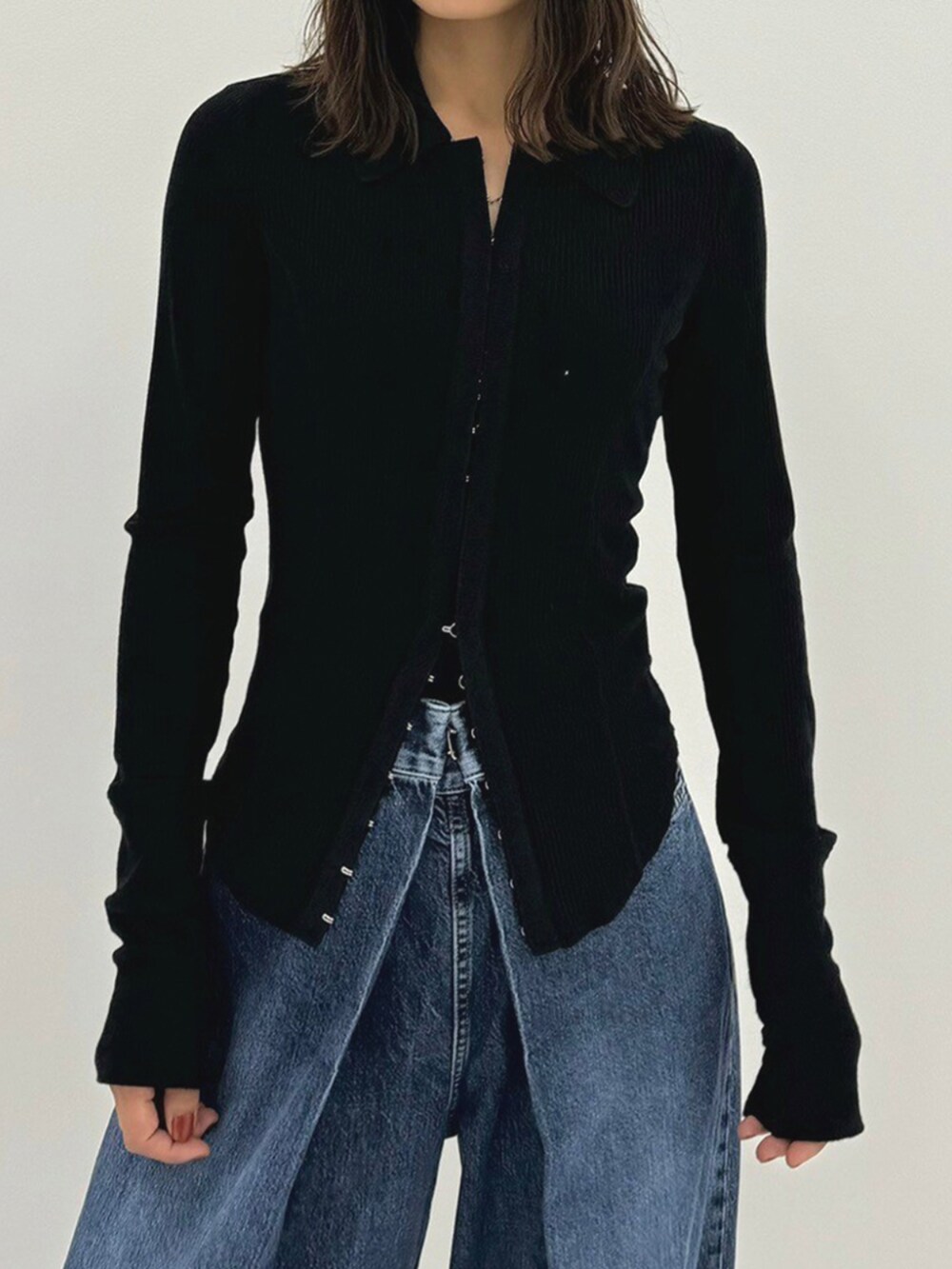 ブルー系のデニムパンツ、レッド系のハンドバッグ、ブラック系のポロシャツを着用したレディースの秋コーディネートの3枚目の写真