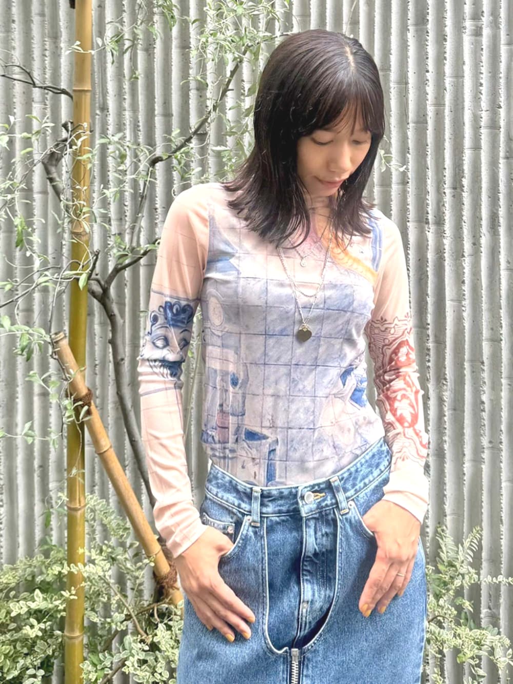 ブラック系のブーツ、ブルー系のデニムスカート、ベージュ系のTシャツ/カットソーを着用したレディースの夏コーディネートの3枚目の写真