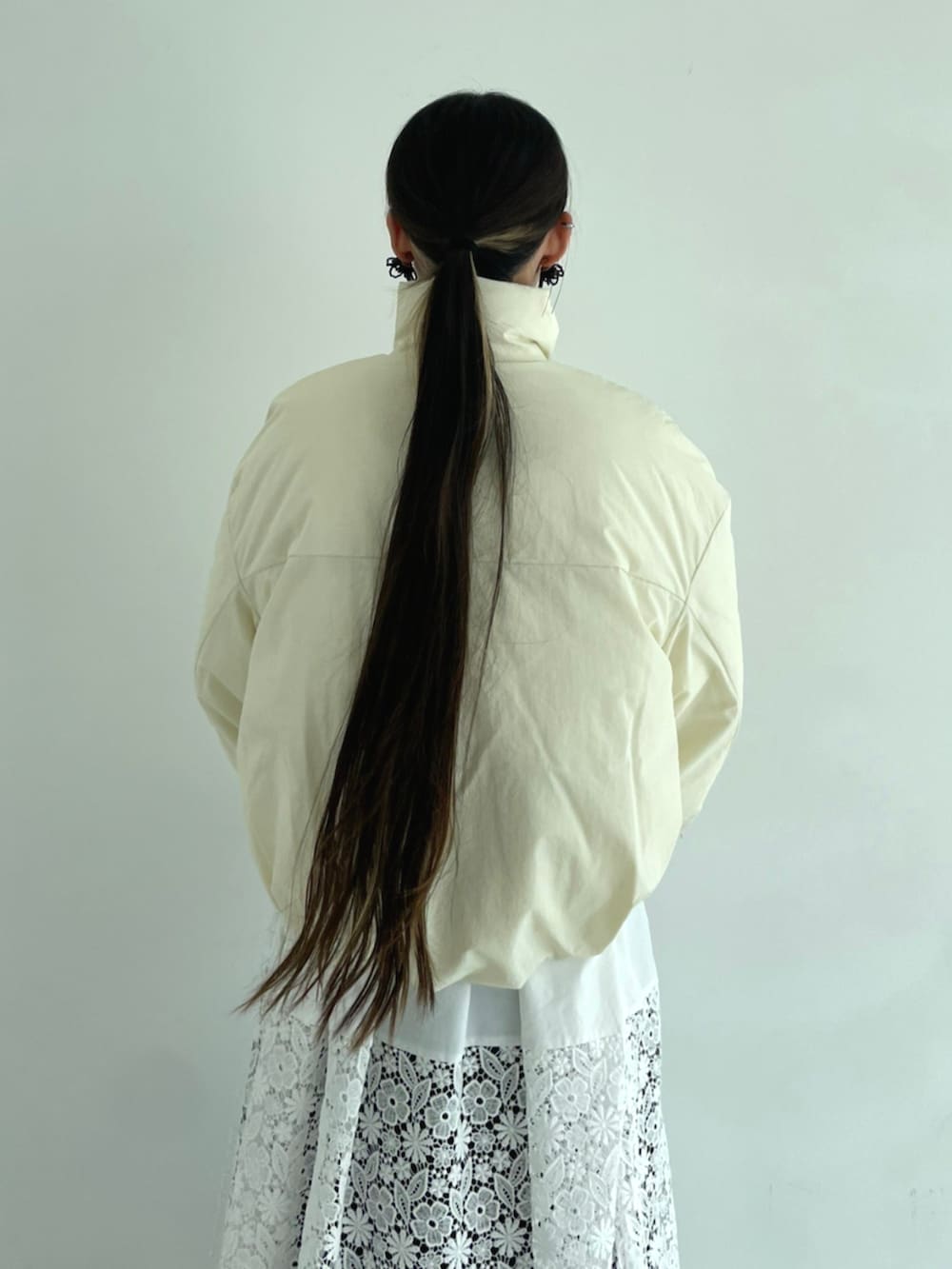 ホワイト系のワンピース、ベージュ系のダウンジャケット/コートを着用したレディースの秋コーディネートの6枚目の写真