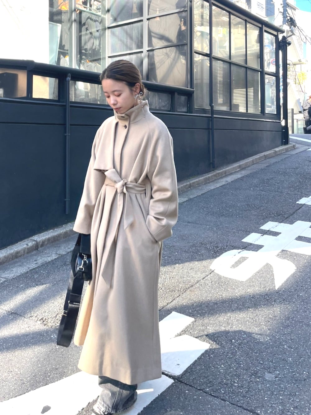 ブラック系のショルダーバッグ、ベージュ系のその他アウターを着用したレディースの秋コーディネートの3枚目の写真