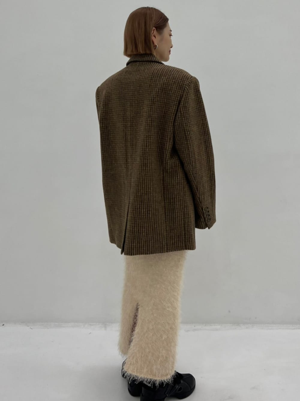 イエロー系のテーラードジャケット、ホワイト系のTシャツ/カットソー、ホワイト系のスカートを着用したレディースの秋コーディネートの3枚目の写真