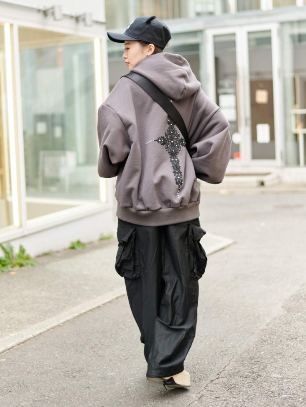 ベージュ系のスリッポン、グレー系のパーカー、ブラック系のキャップを着用したレディースの冬コーディネートの4枚目の写真