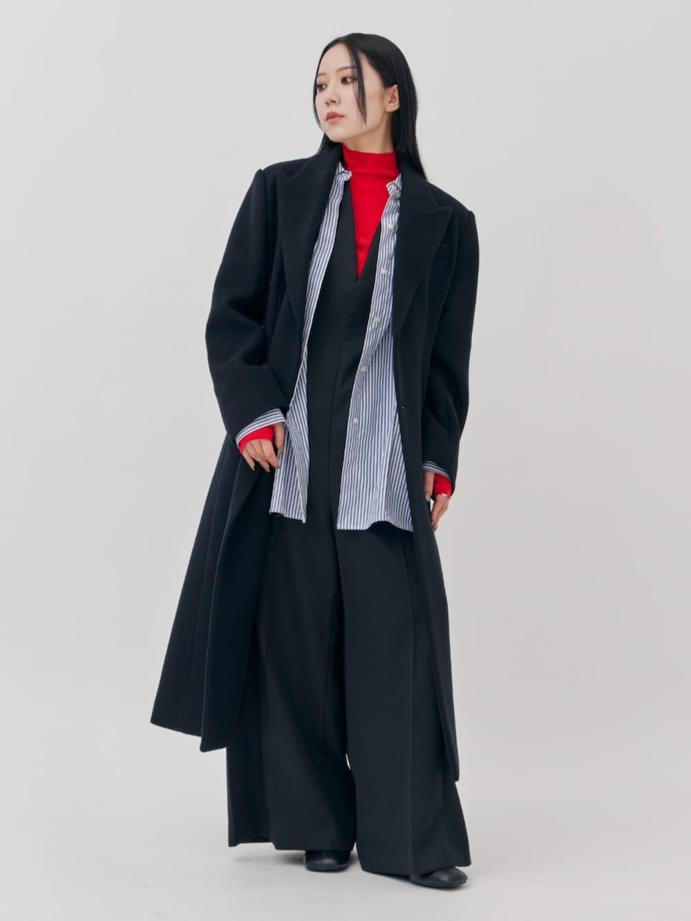 ブラック系のチェスターコートを着用したレディースの秋コーディネートの2枚目の写真