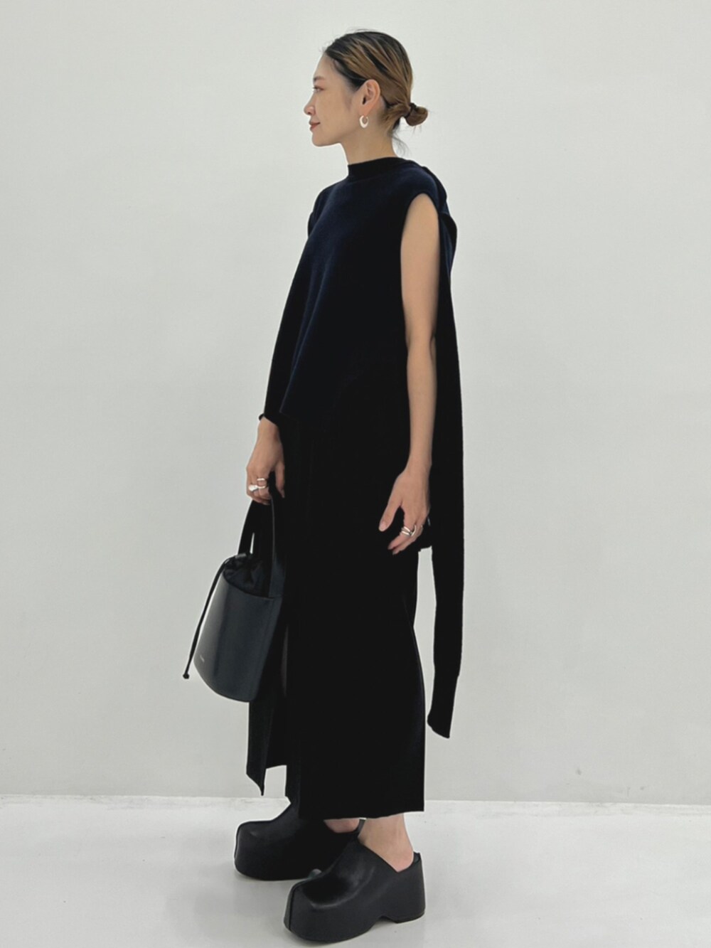 ブラック系のハンドバッグ、ブラック系のスリッポンを着用したレディースの秋コーディネートの2枚目の写真