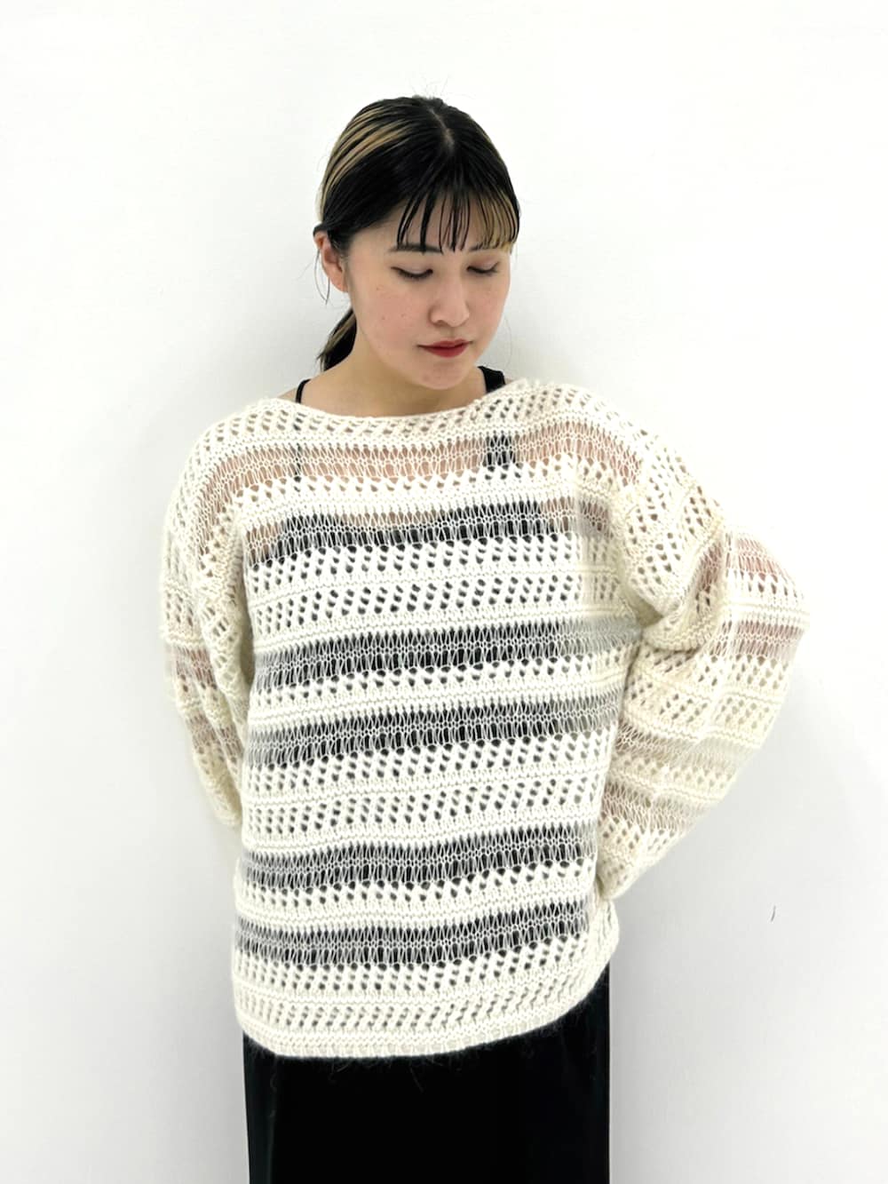 ベージュ系のニット/セーター、ブラック系のスカートを着用したレディースの秋コーディネートの2枚目の写真