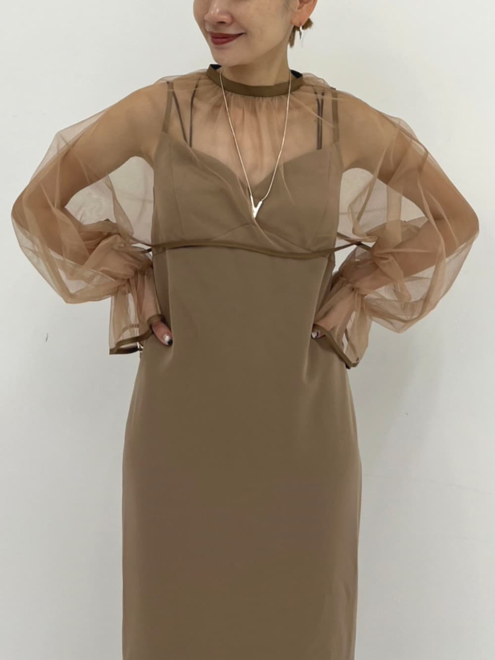 ベージュ系のワンピースを着用したレディースの秋コーディネートの3枚目の写真