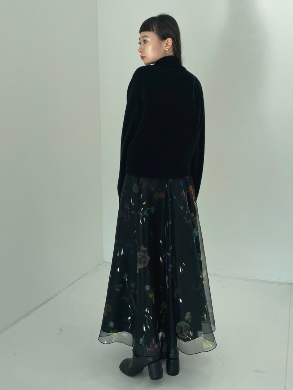 ブラック系のニット/セーターを着用したレディースの秋コーディネートの2枚目の写真