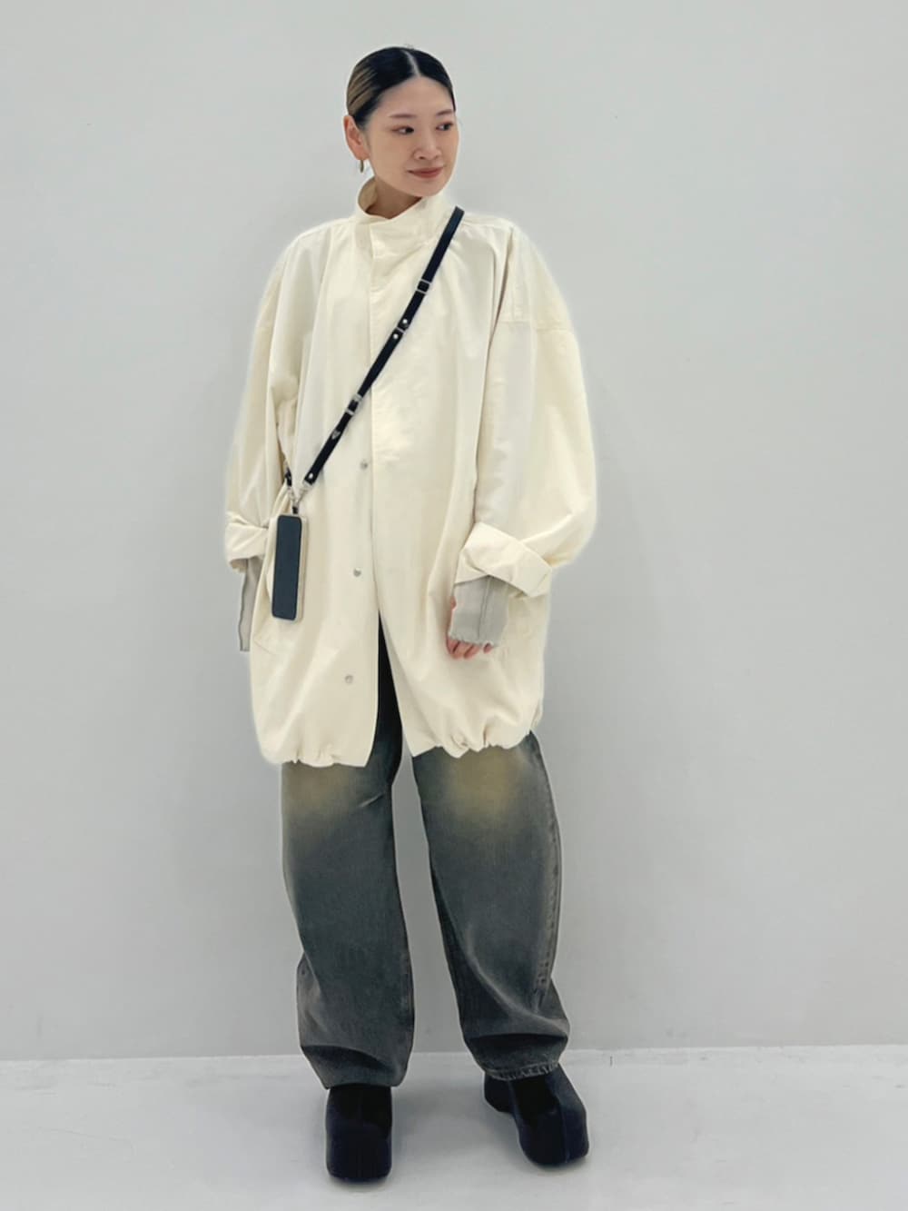 ブルー系のデニムパンツ、ブラック系のスリッポン、ホワイト系のブルゾンを着用したレディースの秋コーディネートの3枚目の写真