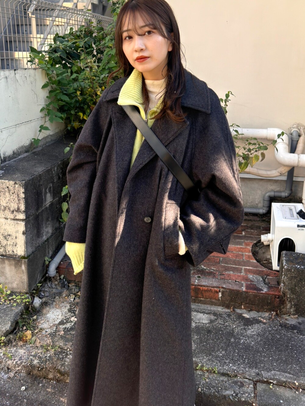 ブルー系のデニムパンツ、グリーン系のニット/セーター、グレー系のその他アウターを着用したレディースの秋コーディネートの3枚目の写真