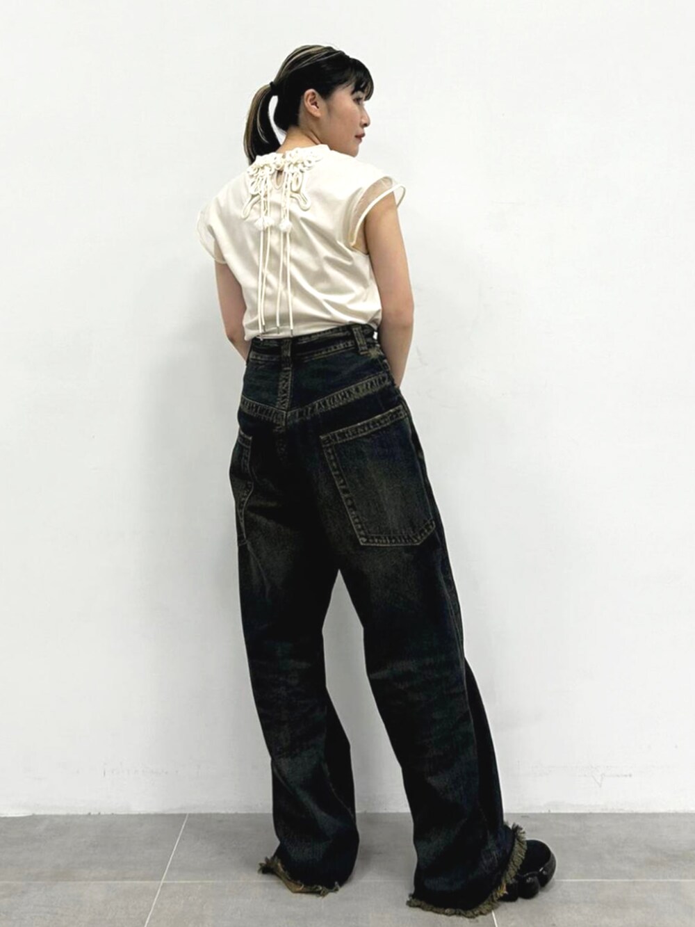 ベージュ系のTシャツ/カットソー、ブラック系のブーツを着用したレディースの夏コーディネートの2枚目の写真