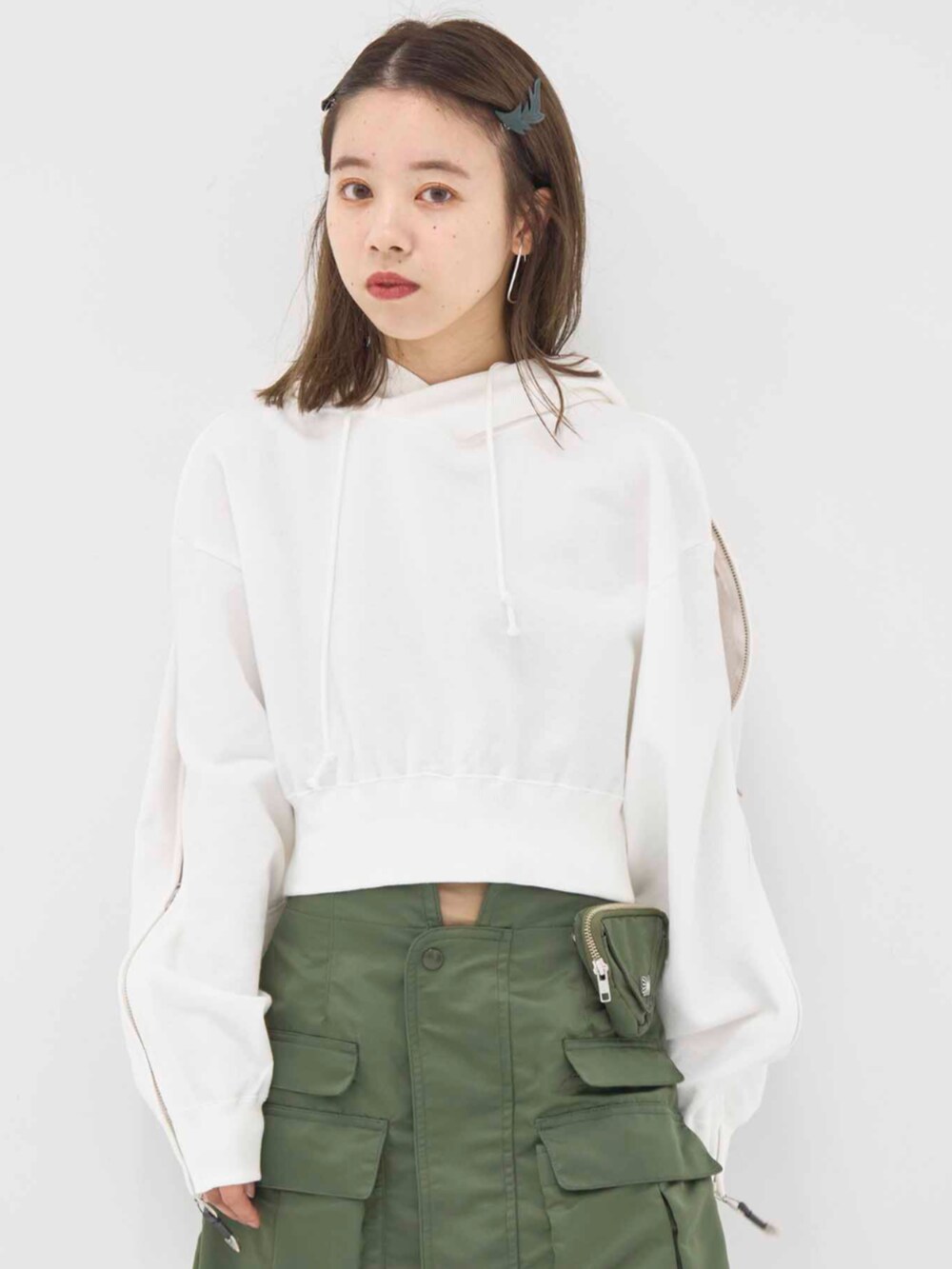 ホワイト系のパーカー、グリーン系のスカートを着用したレディースの冬コーディネートの3枚目の写真