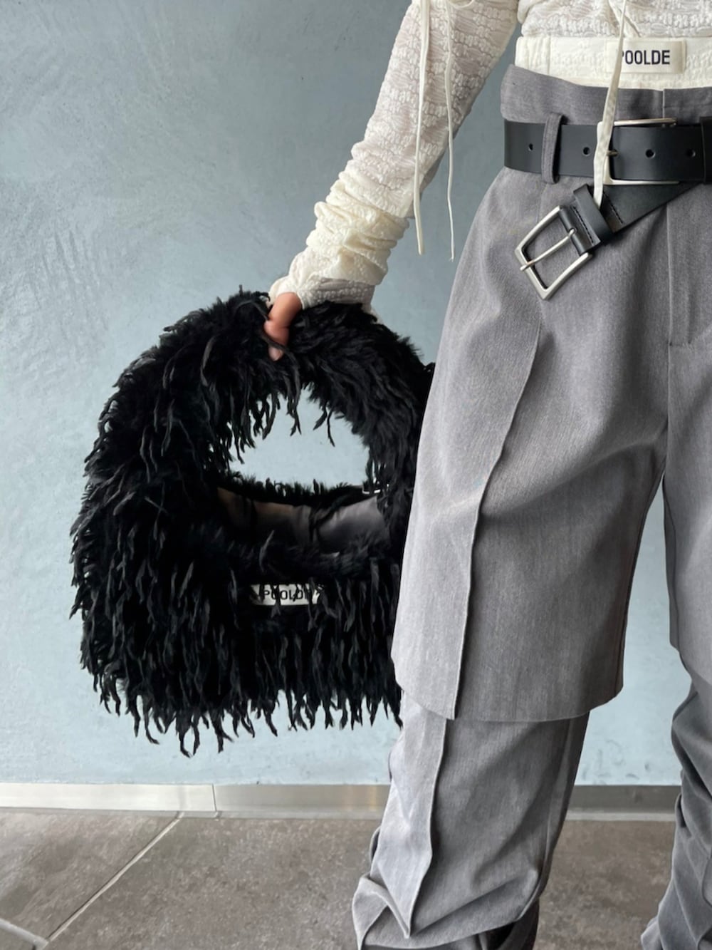 ブラック系のショルダーバッグ、ホワイト系のその他トップス、グレー系のその他パンツを着用したレディースの秋コーディネートの2枚目の写真