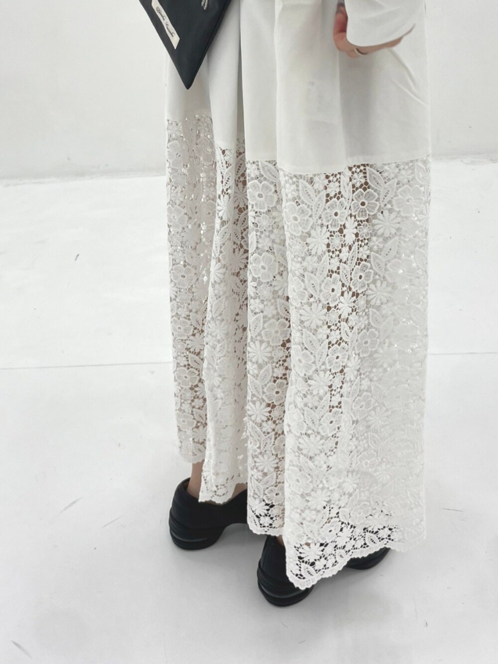 ホワイト系のワンピース、ブラック系のショルダーバッグを着用したレディースの秋コーディネートの4枚目の写真