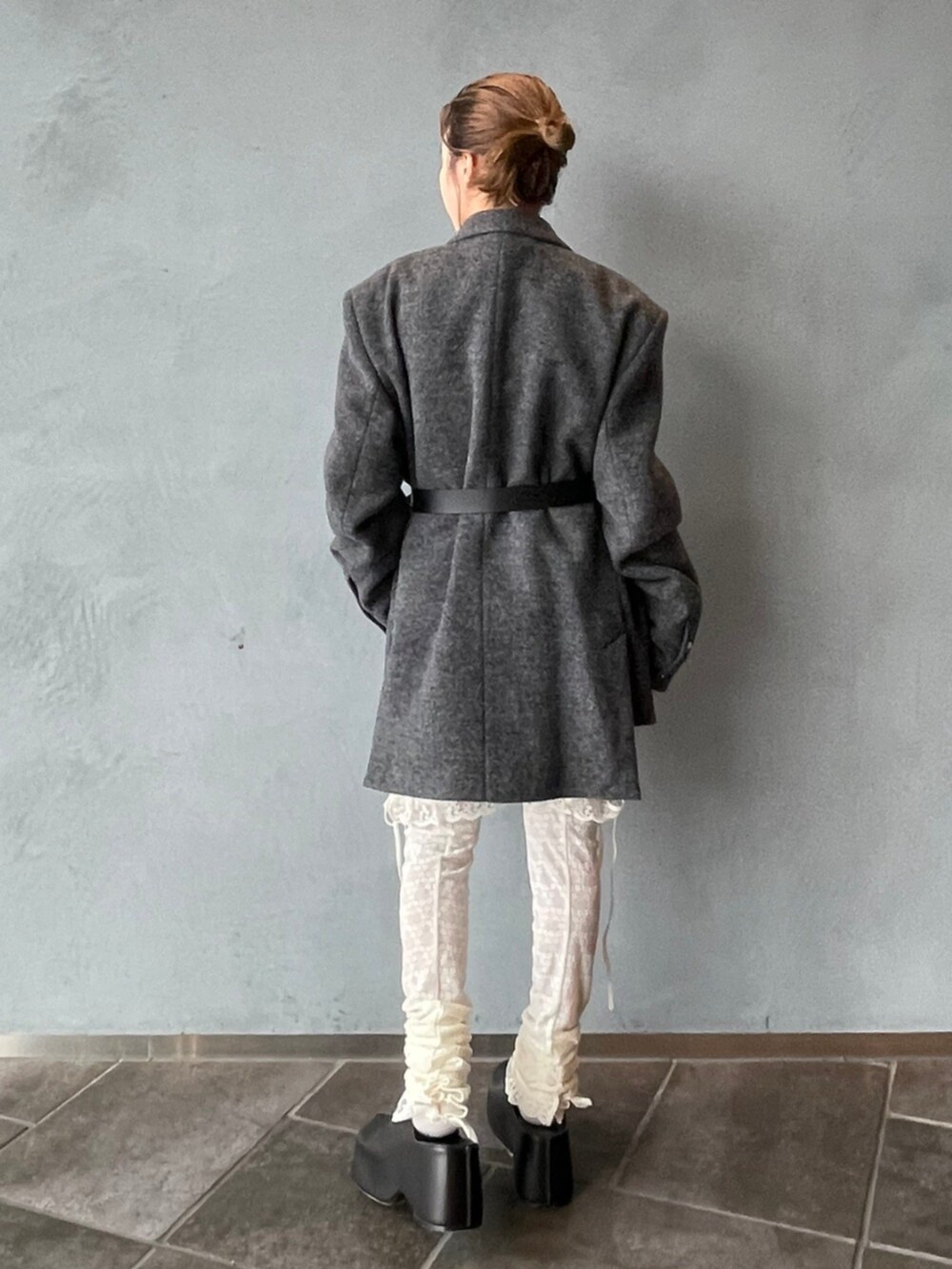 グレー系のテーラードジャケット、ブラック系のベルト、ホワイト系のタイツ/ストッキングを着用したレディースの秋コーディネートの3枚目の写真