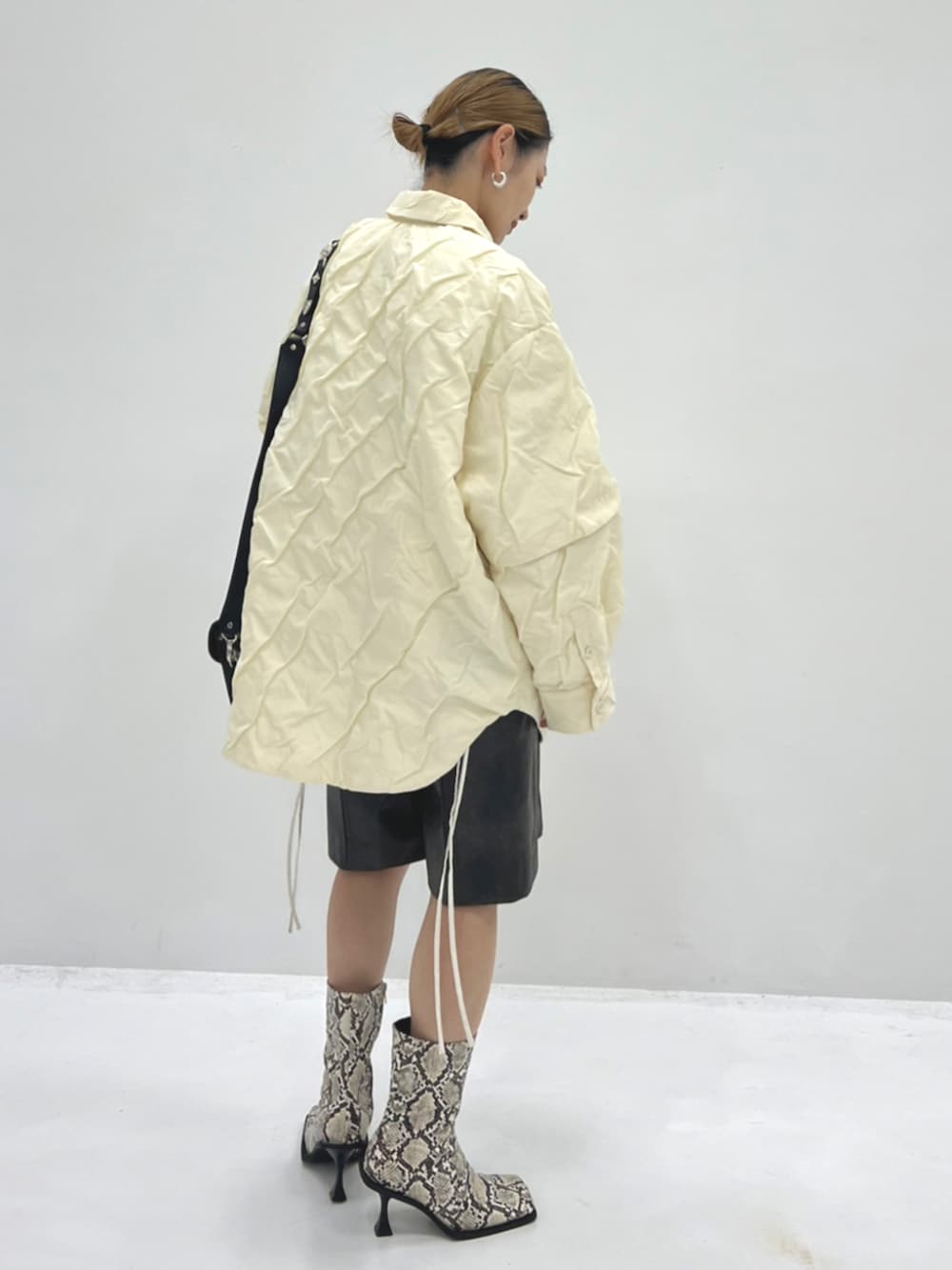 その他のブーツ、ベージュ系のその他アウター、ブラック系のトートバッグを着用したレディースの秋コーディネートの2枚目の写真