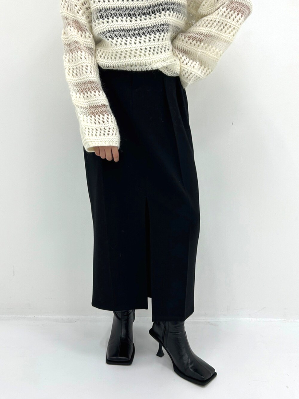 ベージュ系のニット/セーター、ブラック系のスカートを着用したレディースの秋コーディネートの3枚目の写真