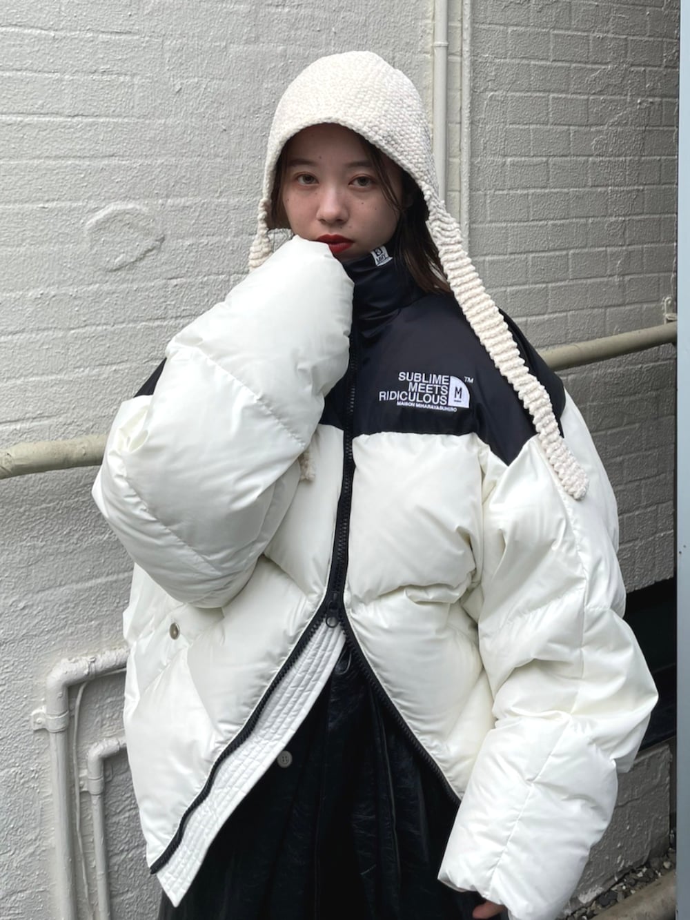 ブラック系のスカート、ホワイト系のダウンジャケット/コートを着用したレディースの秋コーディネートの3枚目の写真