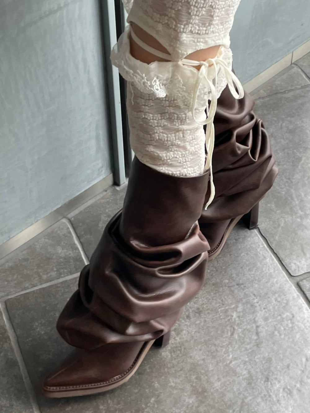 グレー系のテーラードジャケット、ブラウン系のブーツ、ピンク系のショルダーバッグを着用したレディースの秋コーディネートの3枚目の写真