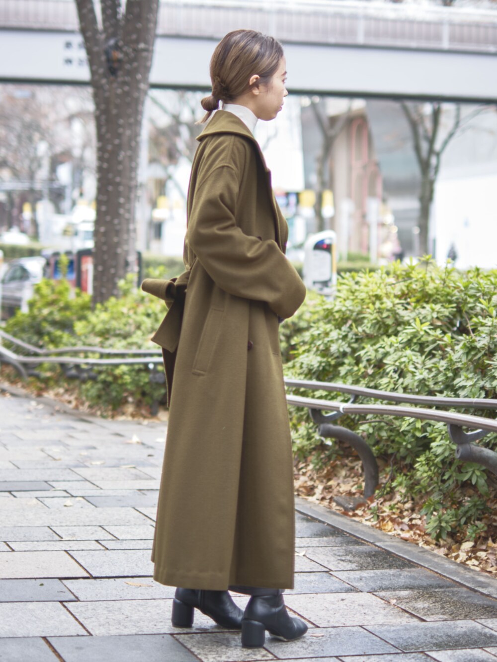 グリーン系のチェスターコートを着用したレディースの冬コーディネートの5枚目の写真