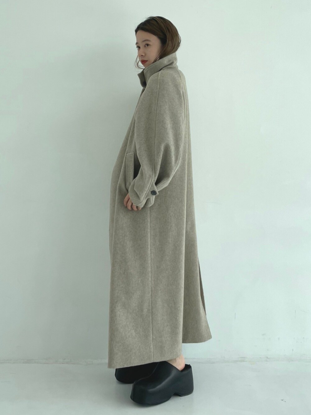 ブラック系のスリッポン、ベージュ系のその他アウターを着用したレディースの秋コーディネートの4枚目の写真