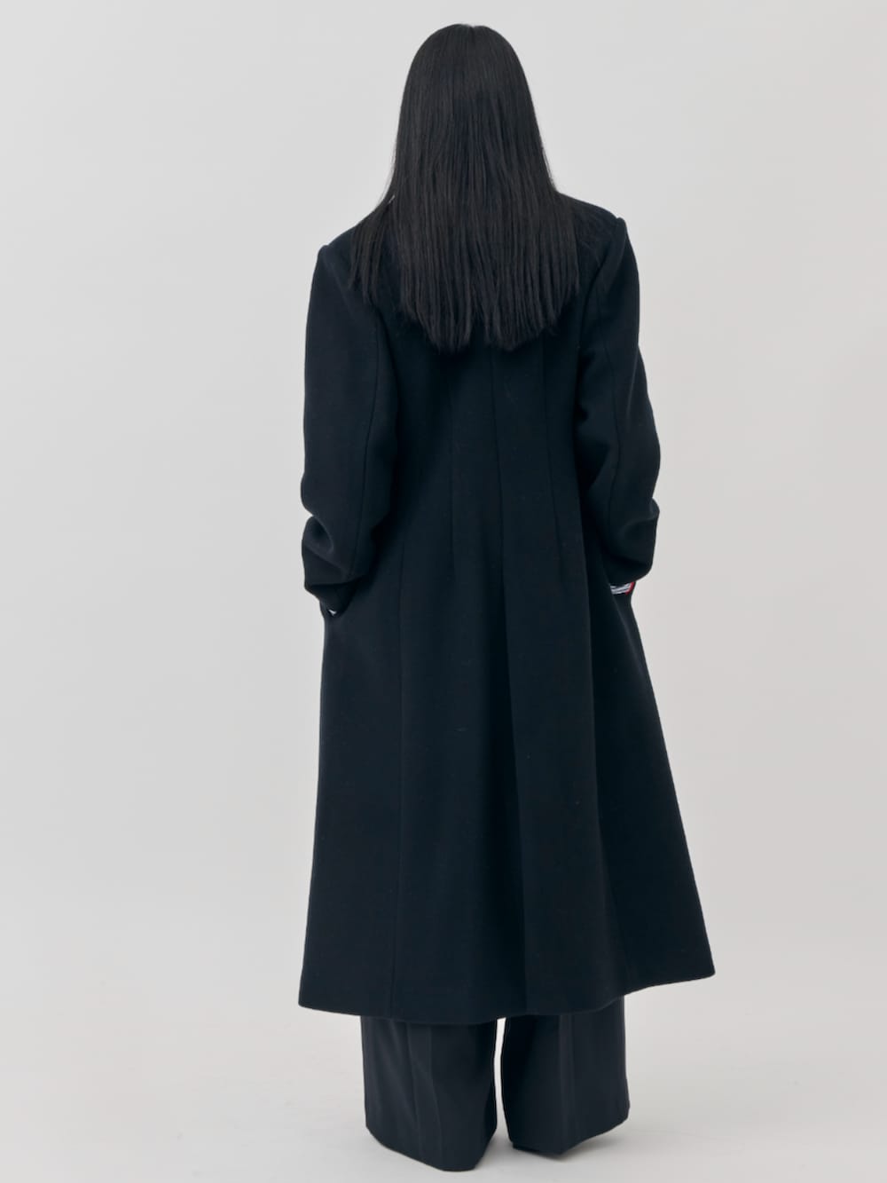 ブラック系のチェスターコートを着用したレディースの秋コーディネートの4枚目の写真