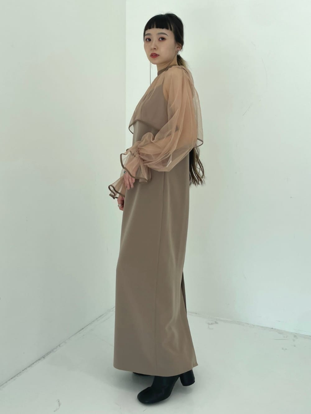 ベージュ系のワンピースを着用したレディースの秋コーディネートの2枚目の写真