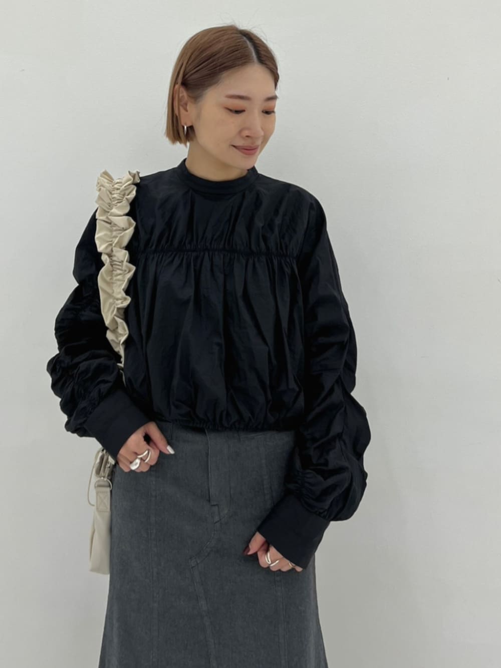 ベージュ系のショルダーバッグ、ブラック系のシャツ/ブラウス、グレー系のスカートを着用したレディースの秋コーディネートの4枚目の写真