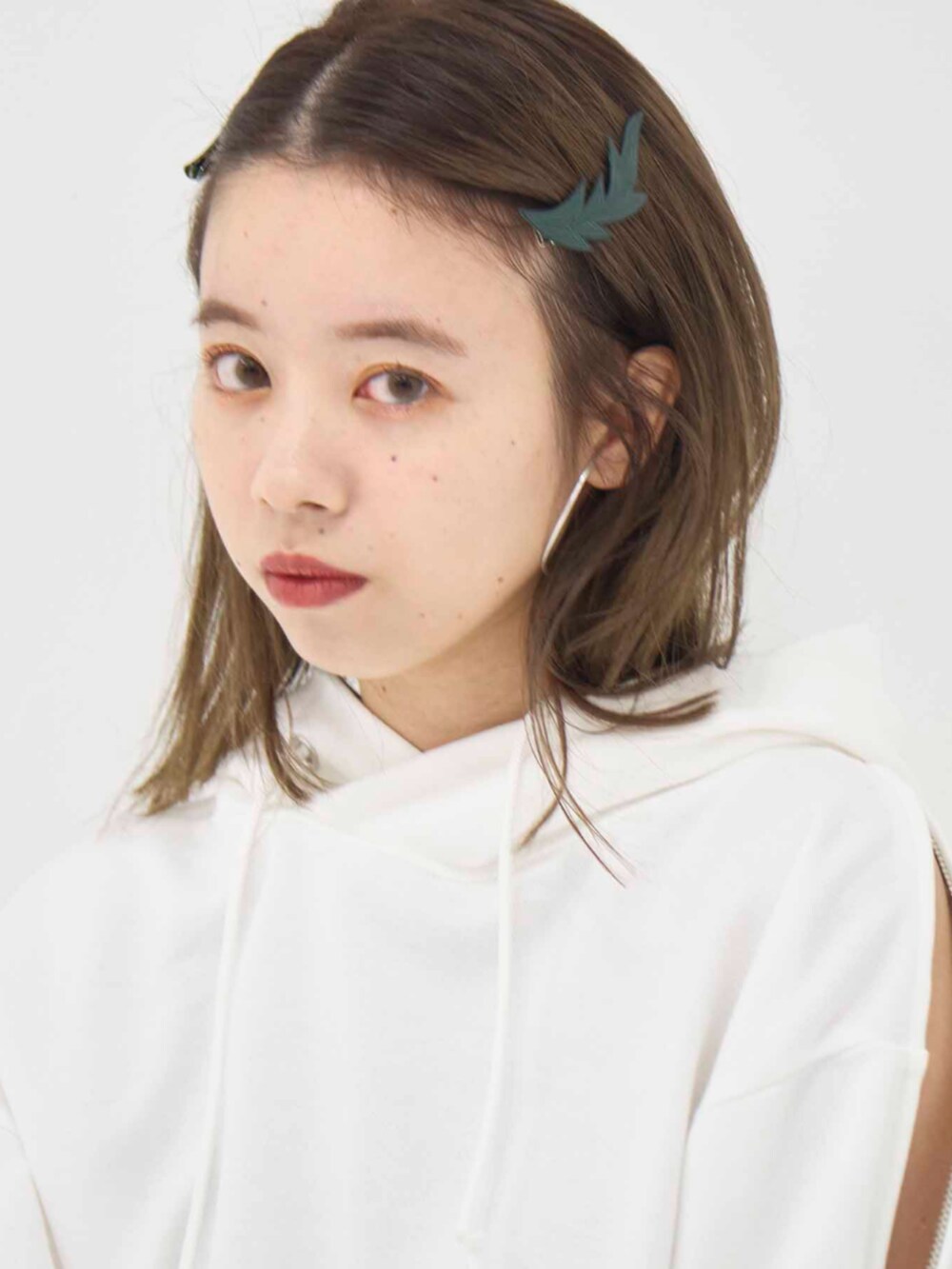 ホワイト系のパーカー、グリーン系のスカートを着用したレディースの冬コーディネートの6枚目の写真