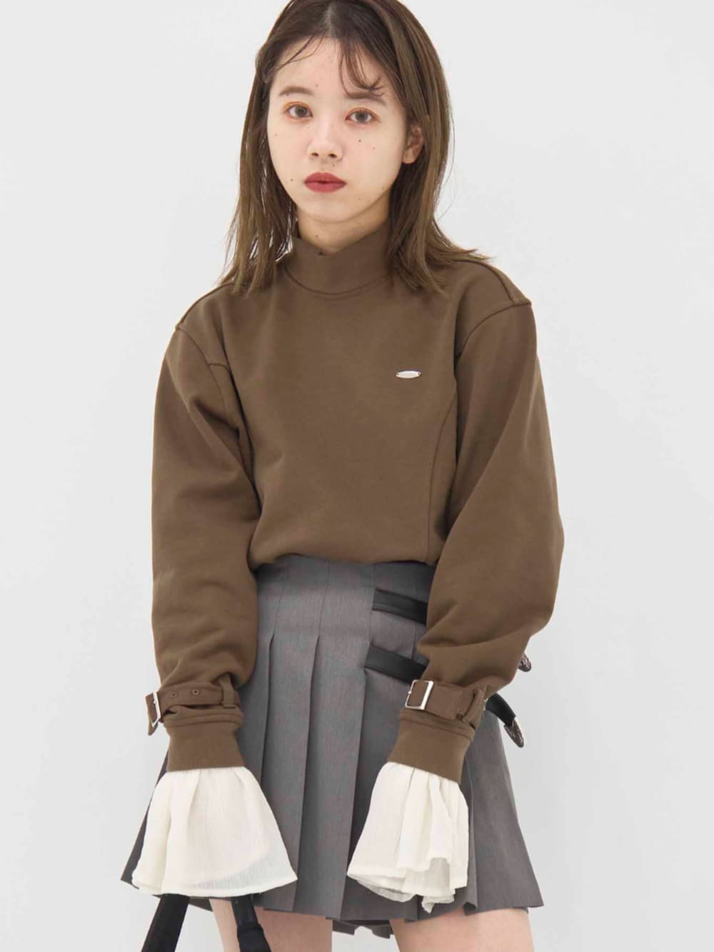 ブラウン系のスウェット、グレー系のスカート、ブラック系のバンダナ/スカーフを着用したレディースの冬コーディネートの2枚目の写真