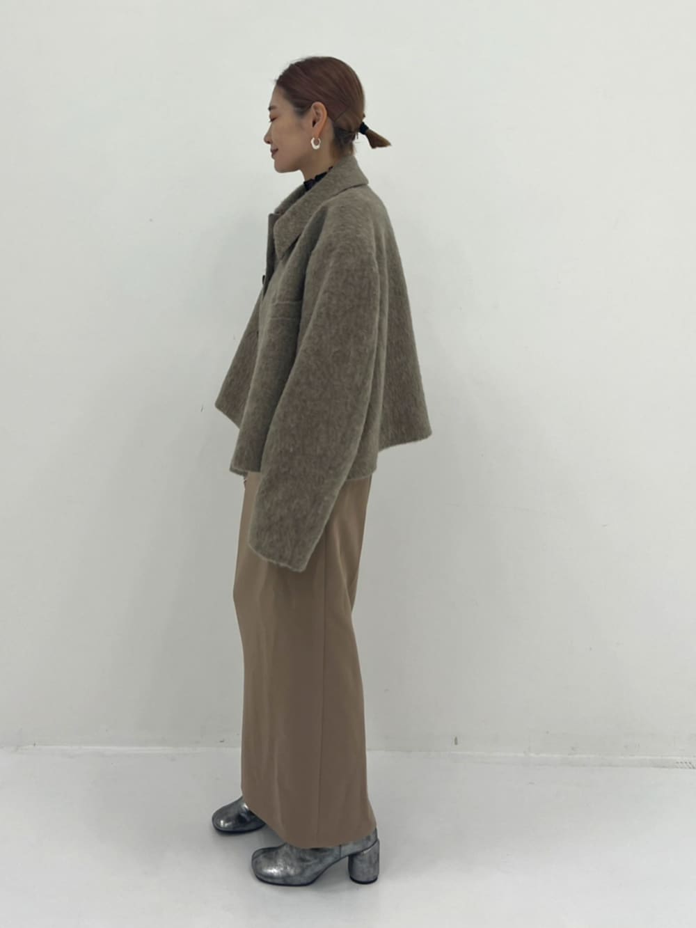 ベージュ系のその他アウター、ベージュ系のワンピース、シルバー系のブーツを着用したレディースの秋コーディネートの2枚目の写真