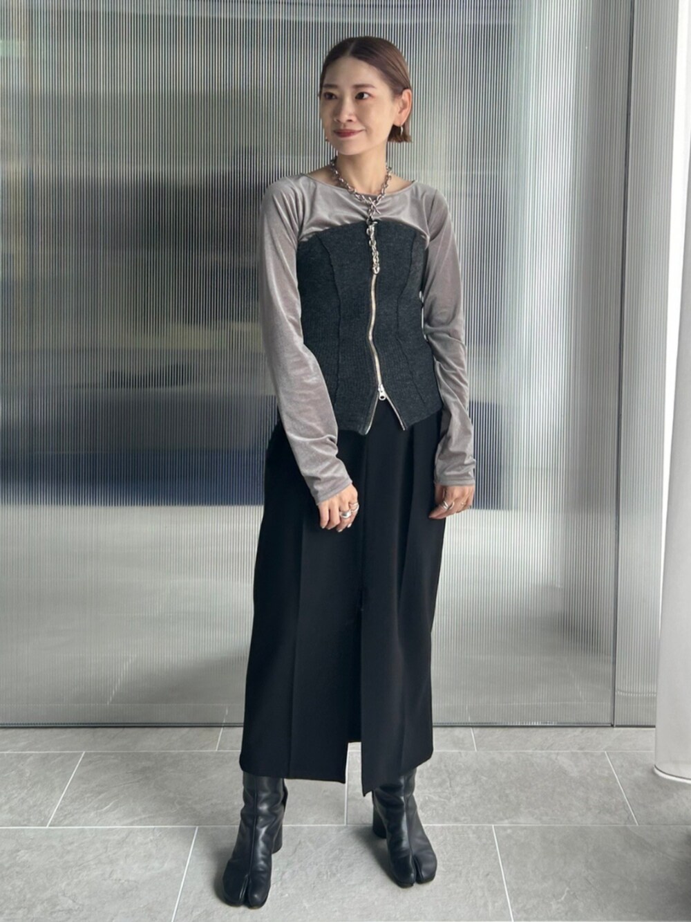 ブラック系のスマホグッズを着用したレディースの秋コーディネートの2枚目の写真