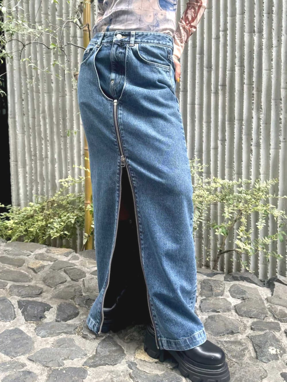 ブラック系のブーツ、ブルー系のデニムスカート、ベージュ系のTシャツ/カットソーを着用したレディースの夏コーディネートの4枚目の写真