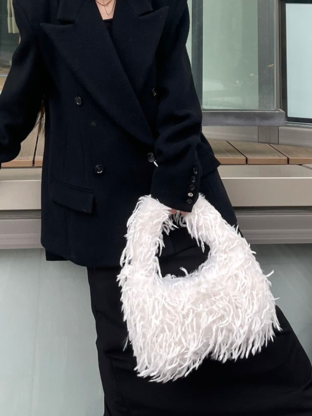 ブラック系のテーラードジャケット、ホワイト系のショルダーバッグを着用したレディースの秋コーディネートの4枚目の写真