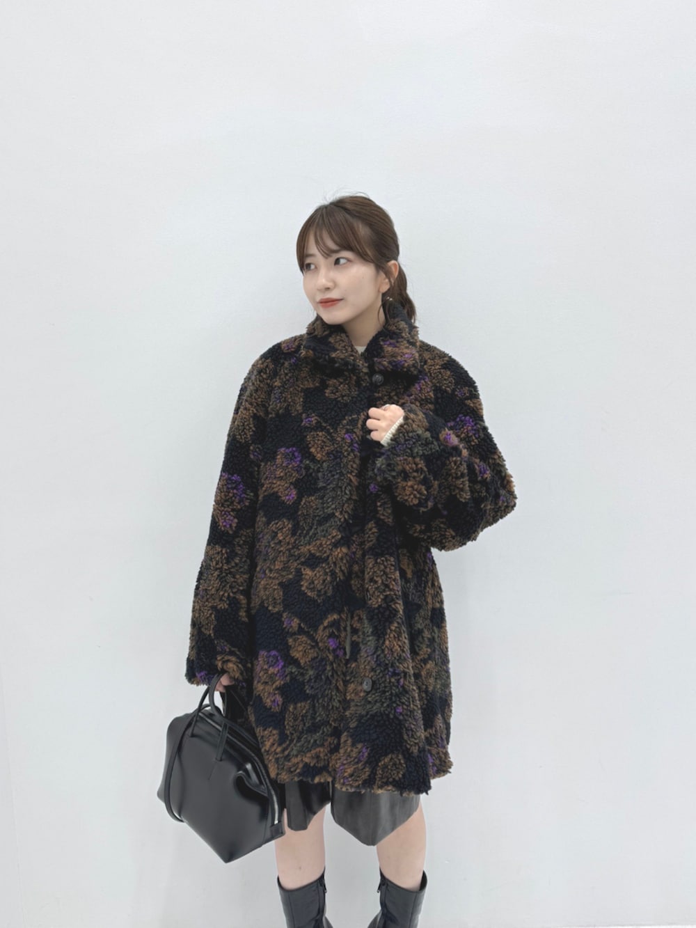 ブラック系のダッフルコート、ブラック系のハンドバッグを着用したレディースの秋コーディネートの3枚目の写真