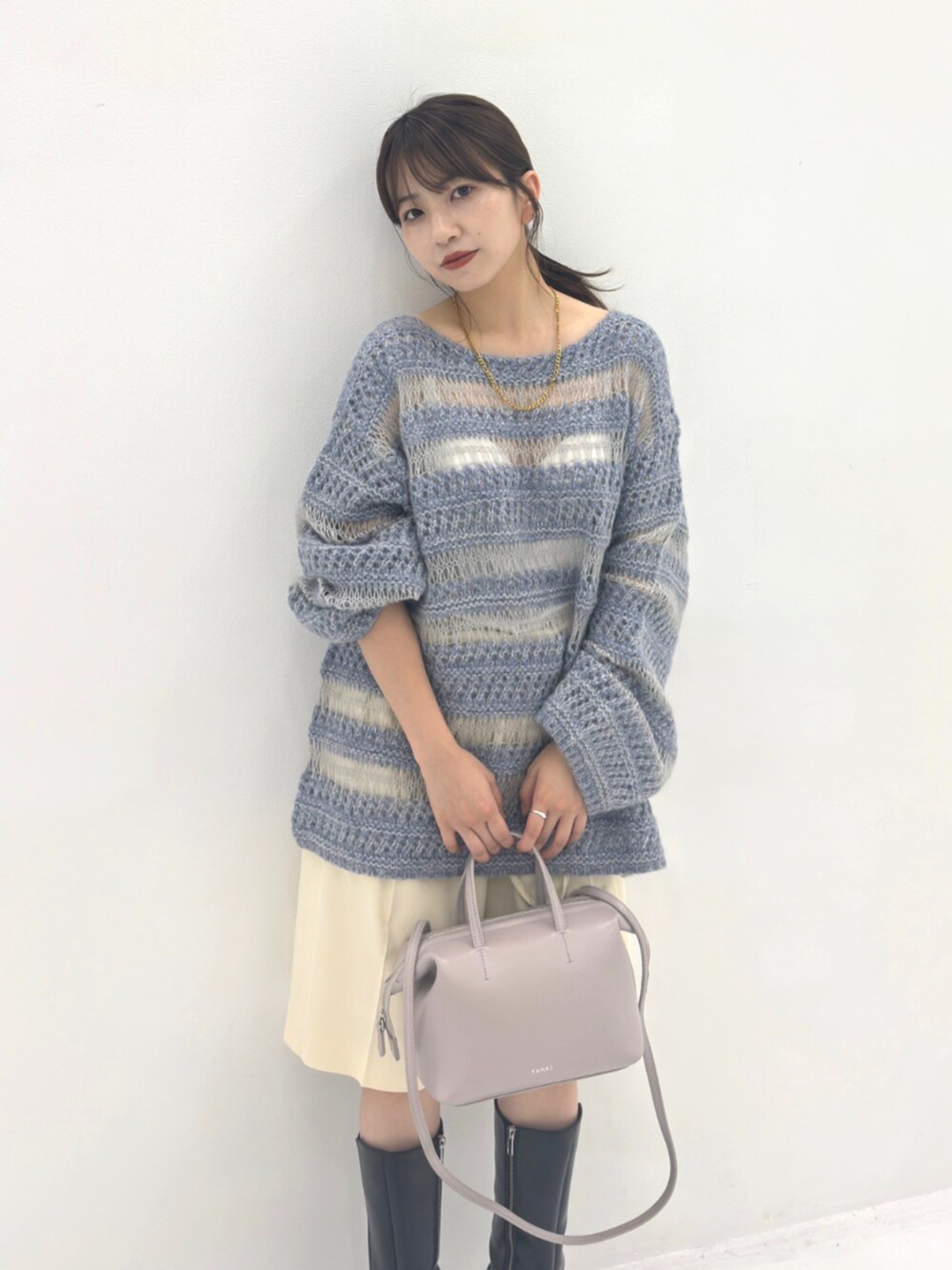 ブラック系のブーツ、ブルー系のニット/セーター、グレー系のハンドバッグを着用したレディースの秋コーディネートの3枚目の写真