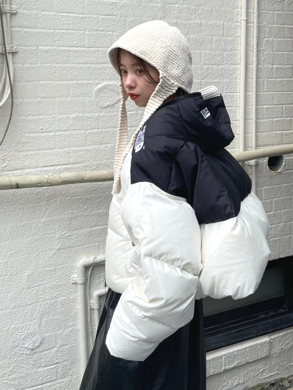 ブラック系のスカート、ホワイト系のダウンジャケット/コートを着用したレディースの秋コーディネートの4枚目の写真